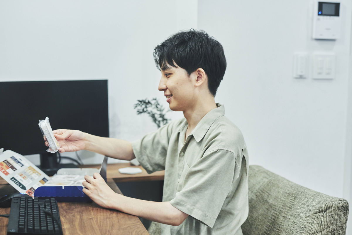 デスクでスナックミーオフィスのお菓子を手に取る男性従業員